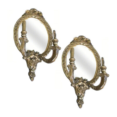 studio shot of a pair of Louis VXI Style carved, oval giltwood mirrors, electrified with 2 candles each